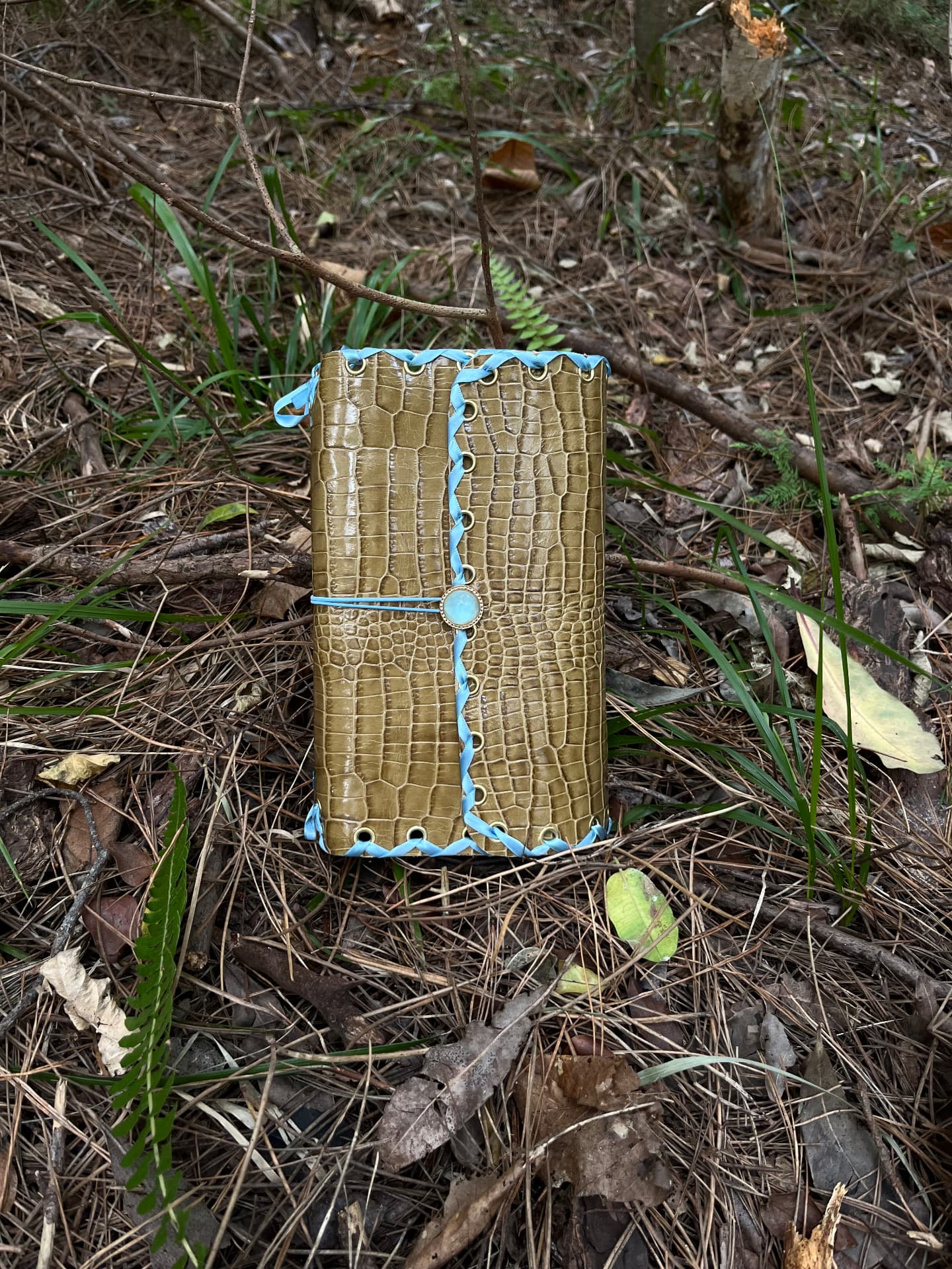Blue laced leather journal resting on linen